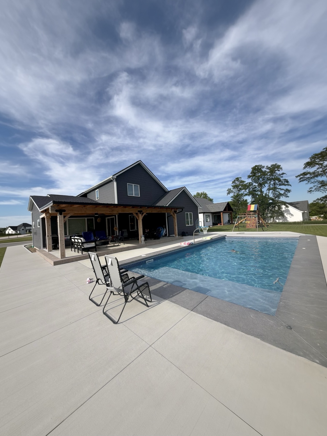 Concrete pool with sun shelf and covered patio in Huntertown